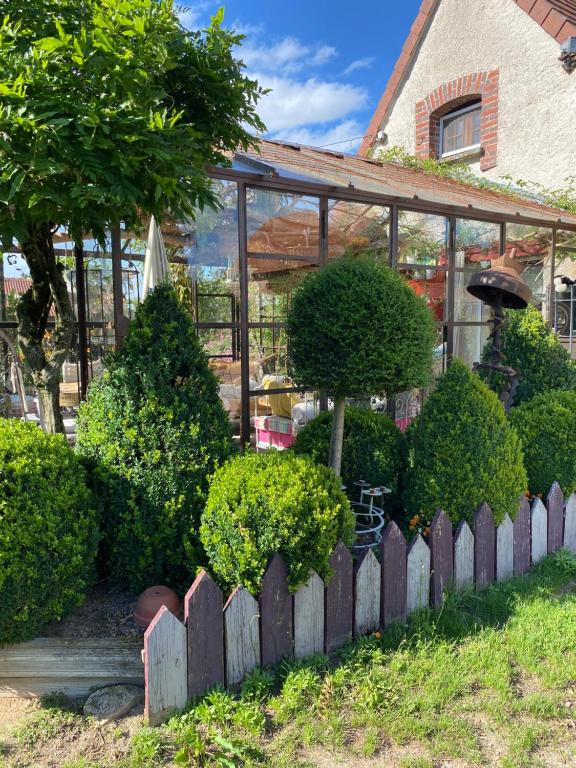 a garden in front of a house with a fence at La Maison du Bonheur in Thiel-sur-Acolin