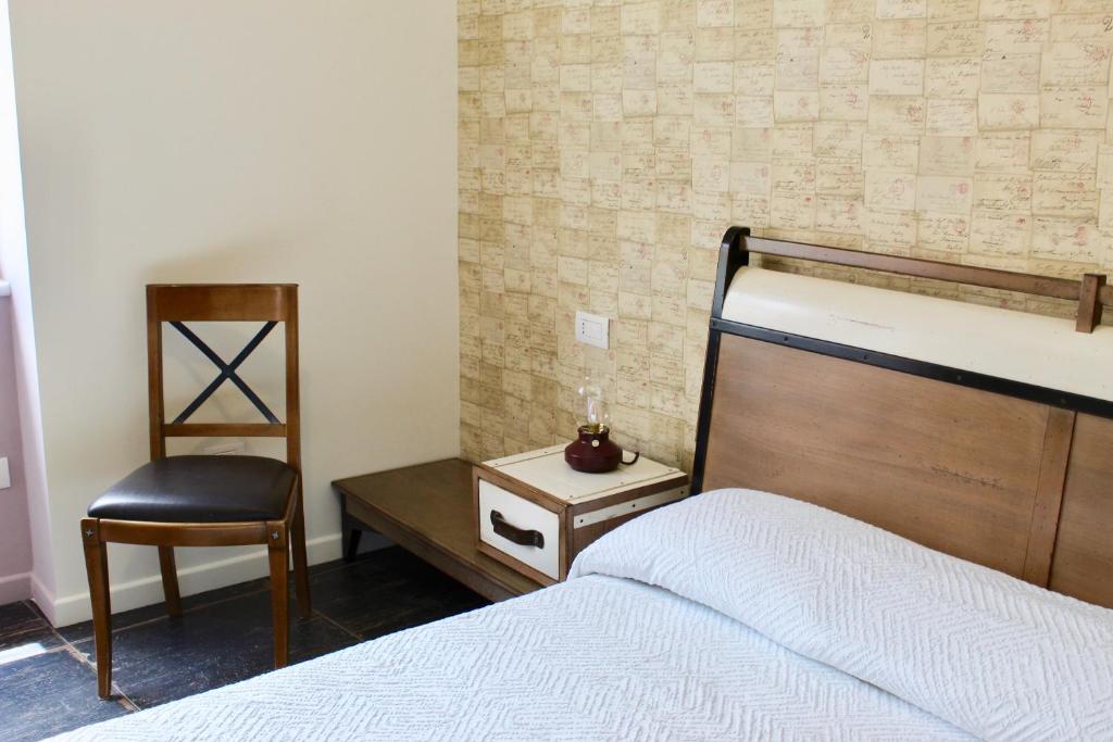 a bedroom with a bed and a chair at Cetara Costa d'Amalfi Residence in Cetara