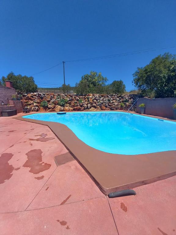 a blue swimming pool on a patio at Quinta do Baquenéu- Sitio das Cortes in Cortes