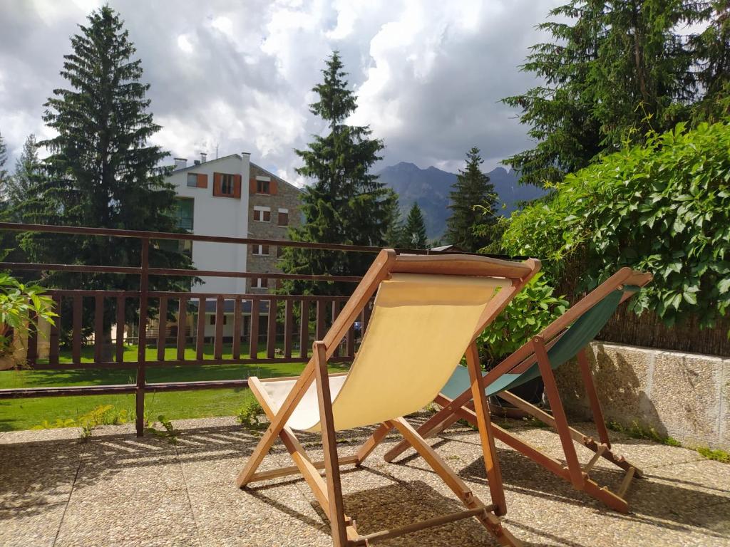 einen Stuhl auf einer Terrasse vor einem Zaun in der Unterkunft Tu Casita de Vacaciones in Aramón Cerler
