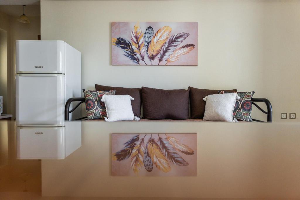 a living room with a couch and paintings on the wall at Mary's Apartments in Argostoli