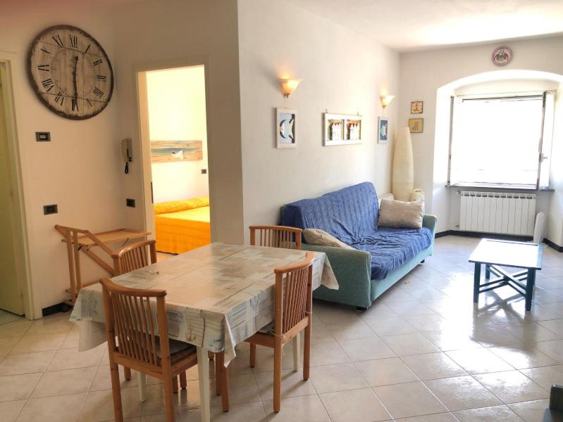 ein Wohnzimmer mit einem Tisch und einem blauen Sofa in der Unterkunft Via Garibaldi Centro Storico in Levanto