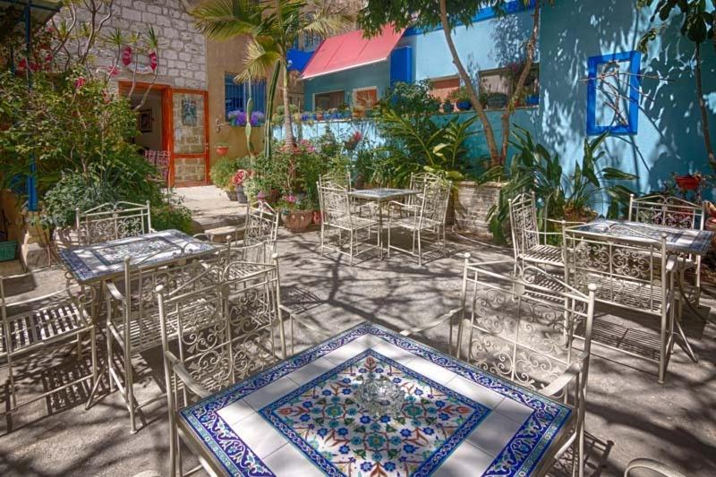 un groupe de tables et de chaises devant un bâtiment dans l'établissement Port Inn, à Haïfa