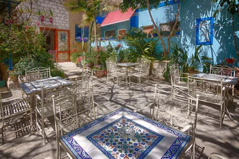 a group of tables and chairs in front of a building at Port Inn in Haifa