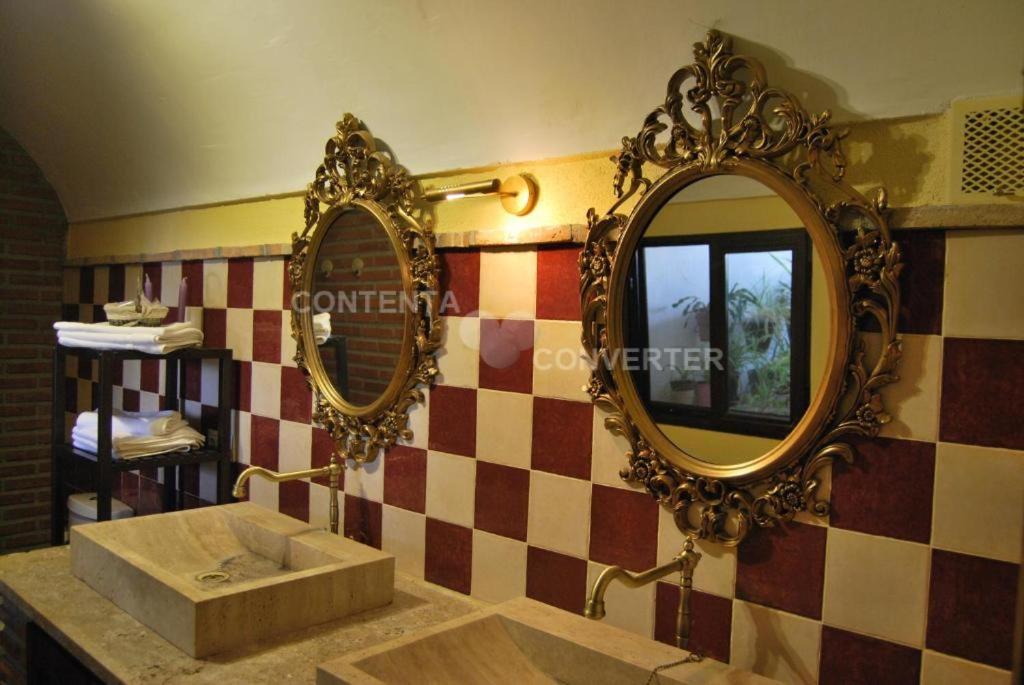 a bathroom with a sink and two mirrors on the wall at Cueva La Ermita in Guadix
