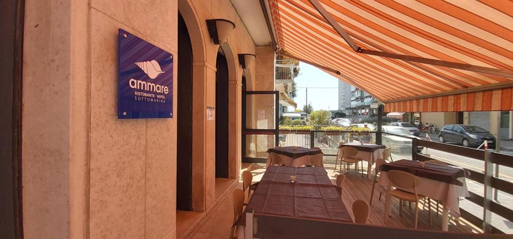 索托馬里納的住宿－Hotel Ammare，阳台餐厅,配有桌椅