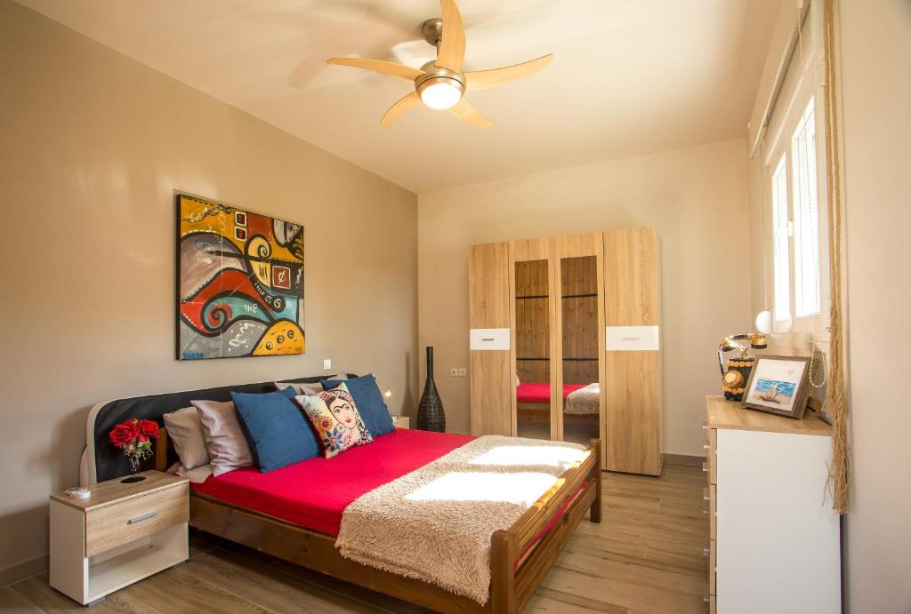 a bedroom with a bed and a ceiling fan at AGGELOS GARDEN VIEW in Faliraki