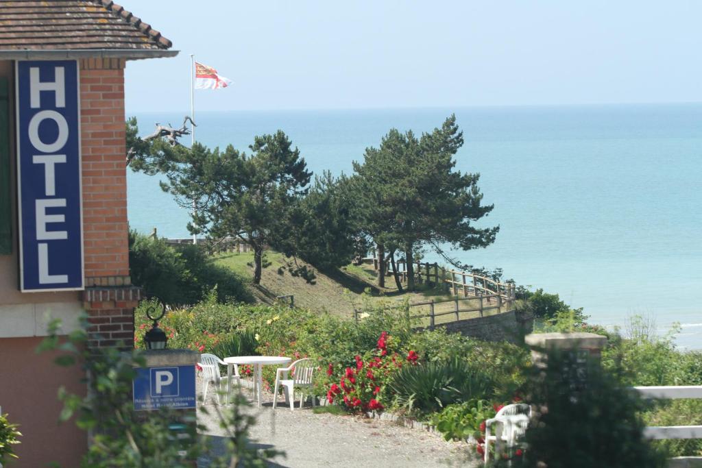 una señal para un hotel con una colina con mesas y flores en Hotel Royal Albion, en Mesnil-Val-Plage