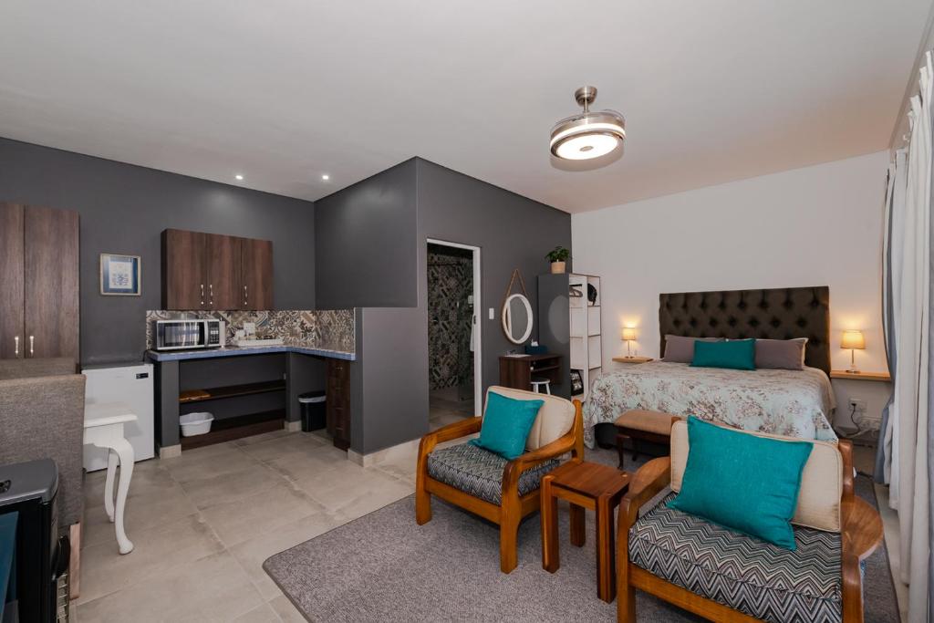 a bedroom with a king sized bed and a kitchen at Emanuel Stay in George