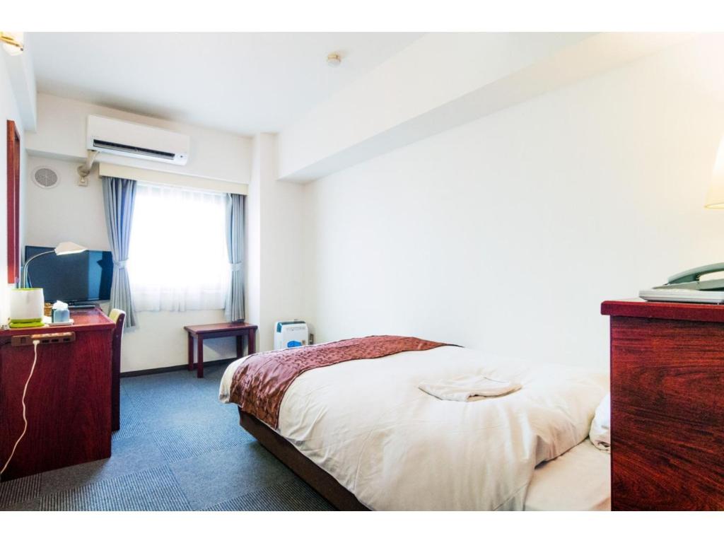 ein Schlafzimmer mit einem Bett, einer Kommode und einem Fenster in der Unterkunft Sky Heart Hotel Koiwa - Vacation STAY 49100v in Tokio