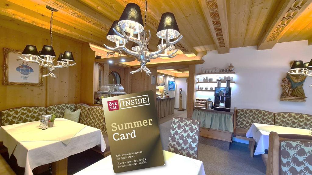 um restaurante com mesas e um sinal para um cartão de verão em Frühstückspension MAIER em Sölden