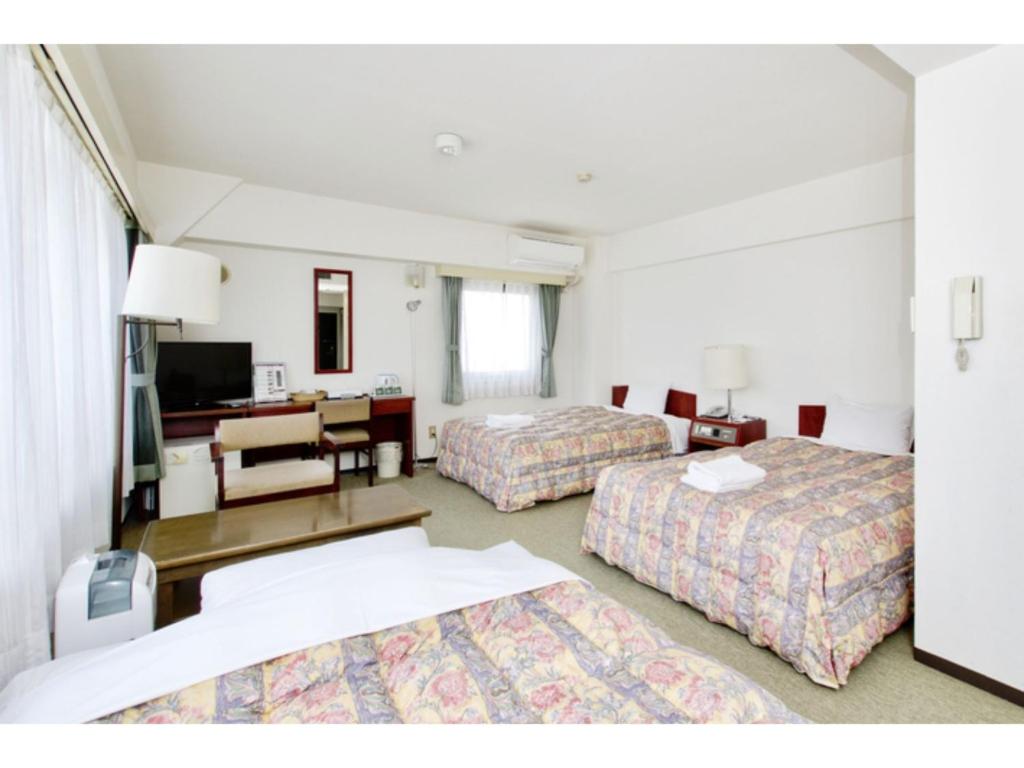 东京Sky Heart Hotel Koiwa - Vacation STAY 49104v的一间有两张床和一间客厅的酒店房间