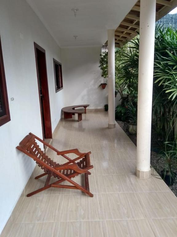 a wooden bench sitting in a room with plants at Vila do Aconchego in Ubatuba