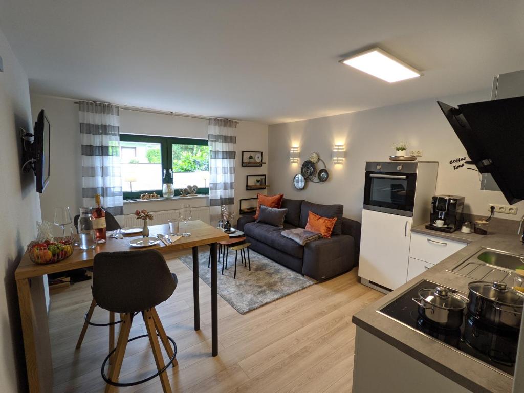 a kitchen and living room with a table and a couch at Ferienwohnung Am Waldweg in Kaisersesch