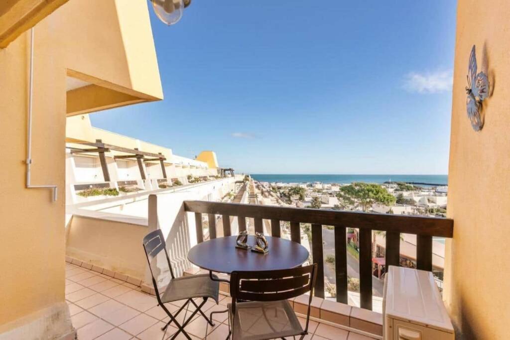 un balcon avec une table et des chaises et l'océan dans l'établissement Sea View Port Nature 5, au Cap d'Agde