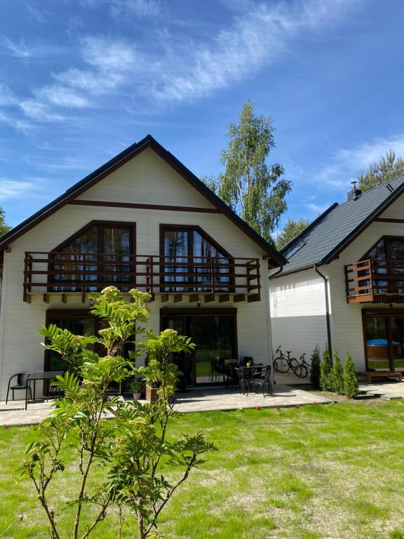 a large white house with windows and a yard at Jarzębinowy Zakątek in Kopalino