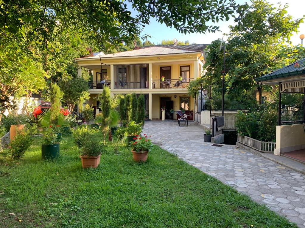 a house with potted plants in the yard at Nargiz's Guest House in Batumi