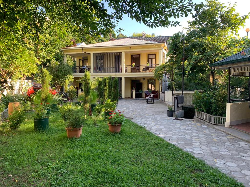 a house with potted plants in the yard at Nargiz&#39;s Guest House in Batumi