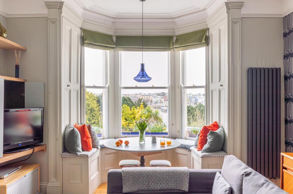 un salon avec une table et une grande fenêtre dans l'établissement Elegant Seaview Apartment, à Bangor