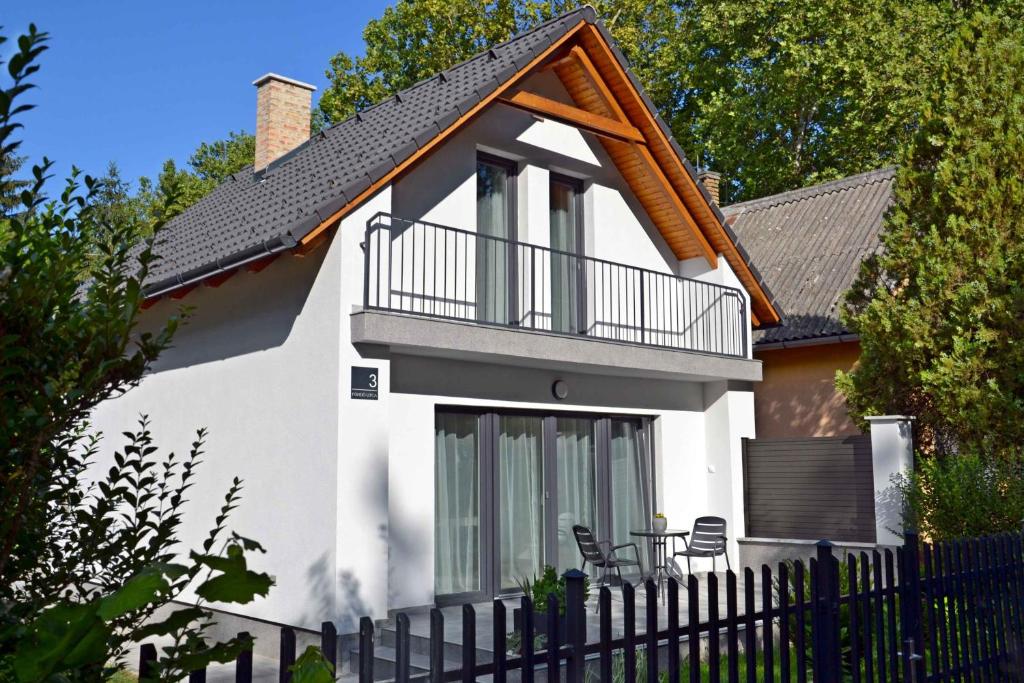 Cette maison blanche dispose d'un balcon et d'une clôture. dans l'établissement Fanni Vendégház, à Dombóvár