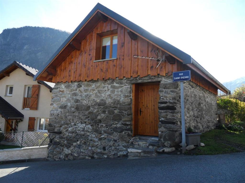 ein Gebäude aus Stein und Holz mit einem Schild davor in der Unterkunft le Sarto - St Jean de Maurienne in Saint-Jean-de-Maurienne