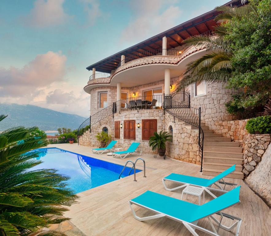 a villa with a swimming pool and a house at Villa Palm Kaş in Kas