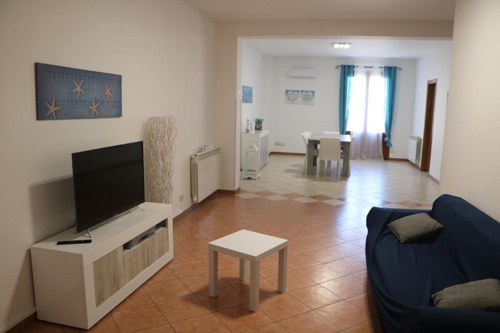 een woonkamer met een tv en een bank en een tafel bij La Casa di Magiù in Terrasini
