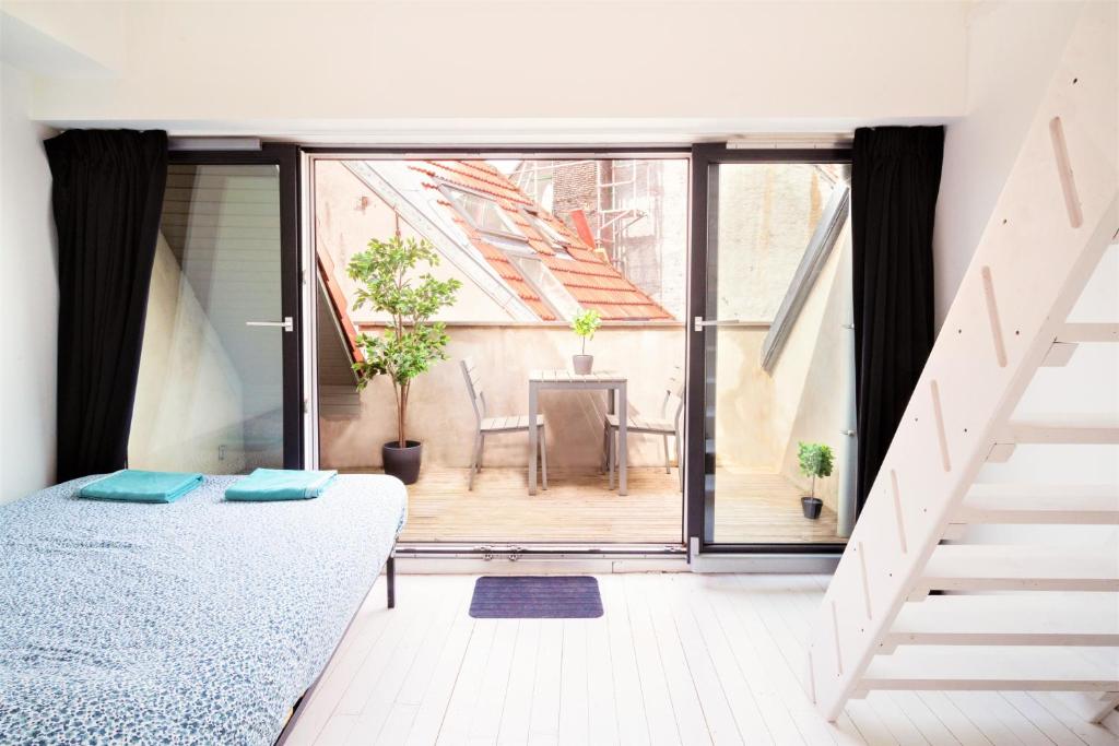 um quarto com uma cama e uma varanda em Beautiful Terrace Apartment in the Heart of Antwerp em Antuérpia