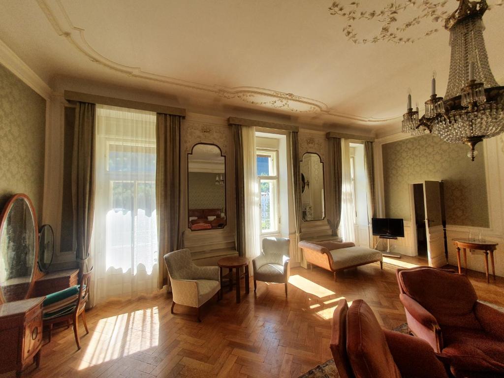 sala de estar con muebles y lámpara de araña. en Belle Époque Panorama Apartment, en Bad Gastein