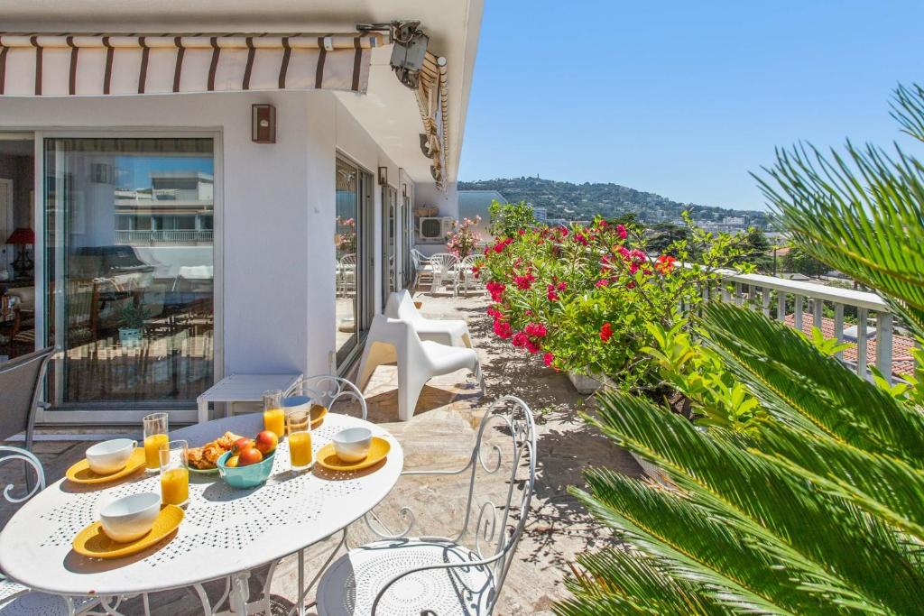 une table et des chaises sur le balcon d'une maison dans l'établissement Le Panoramique Croisette - Welkeys, à Cannes