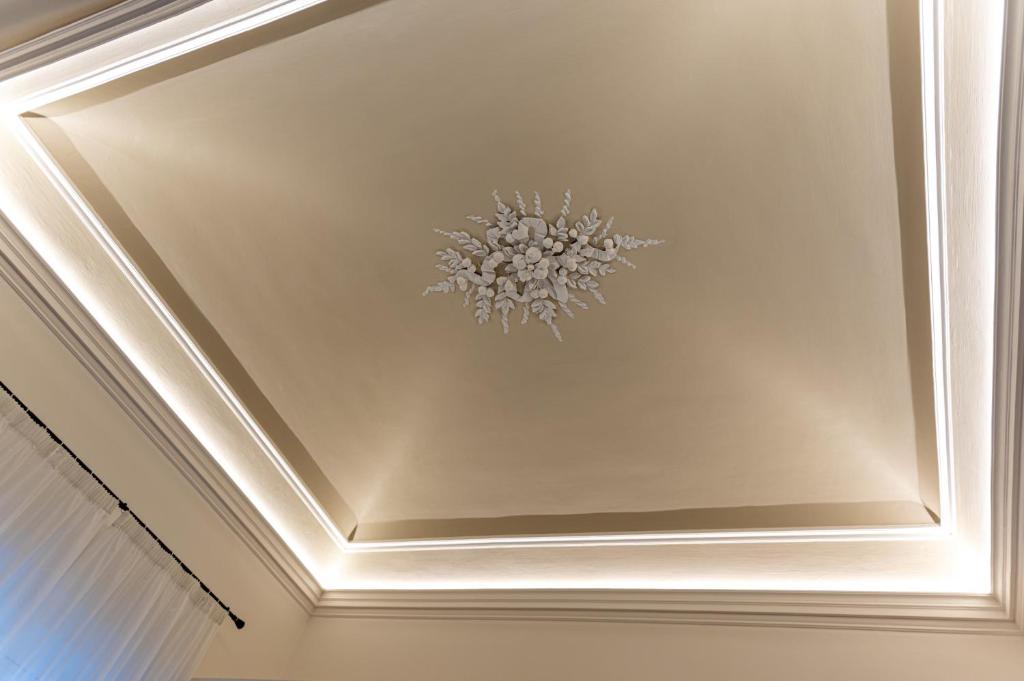a coffered ceiling with a chandelier on it at Ursino's Luxury in Catania