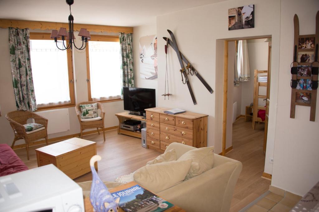 ein Wohnzimmer mit einem Sofa und einem TV in der Unterkunft Courchevel 1550 – VERITABLE SKI AUX PIEDS – APPARTEMENT LES TOVETS T2 – 47m2 – 4P in Courchevel