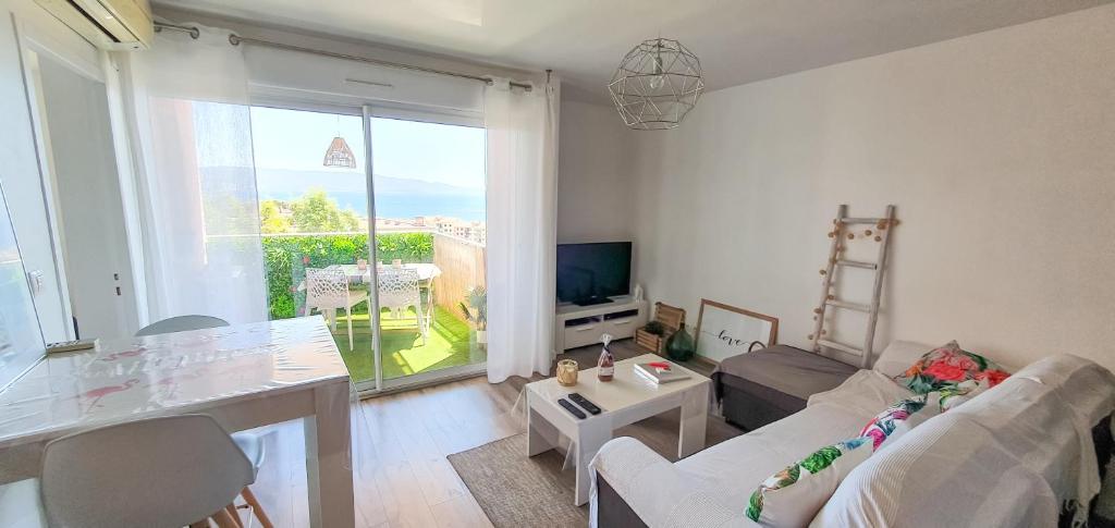 a living room with a couch and a table and a television at Appartement Ajaccio vue mer panoramique in Ajaccio