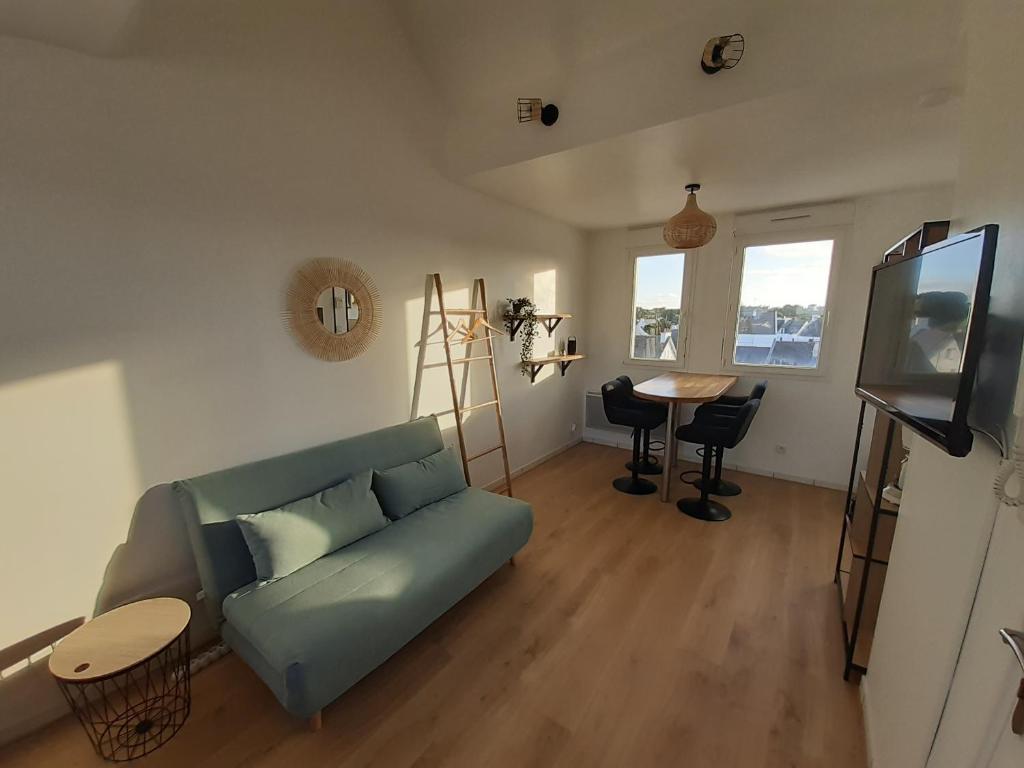 a living room with a couch and a table at Studio calme 20m² à 500 mètres de la plage/ centre in Saint-Pierre-Quiberon