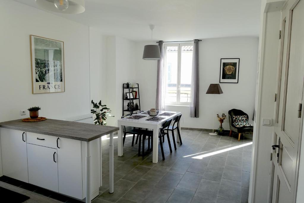 - une cuisine et une salle à manger avec une table et des chaises dans l'établissement Maison Carrée/Coeur historique de Nîmes - Superbe Appt 55m², à Nîmes