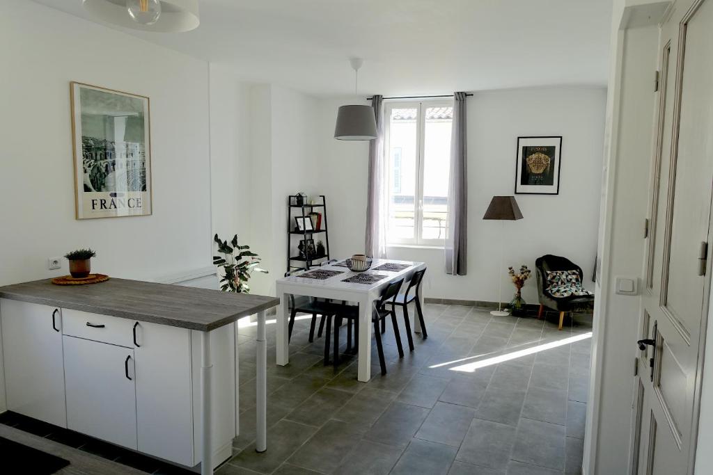 une cuisine et une salle à manger avec une table et des chaises dans l'établissement Maison Carrée/Coeur historique de Nîmes - Superbe Appt 55m², à Nîmes