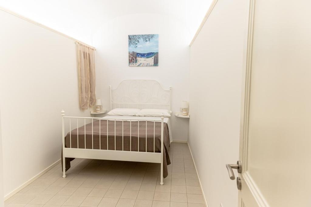 a small white bedroom with a bed in a room at Ursino's Luxury in Catania