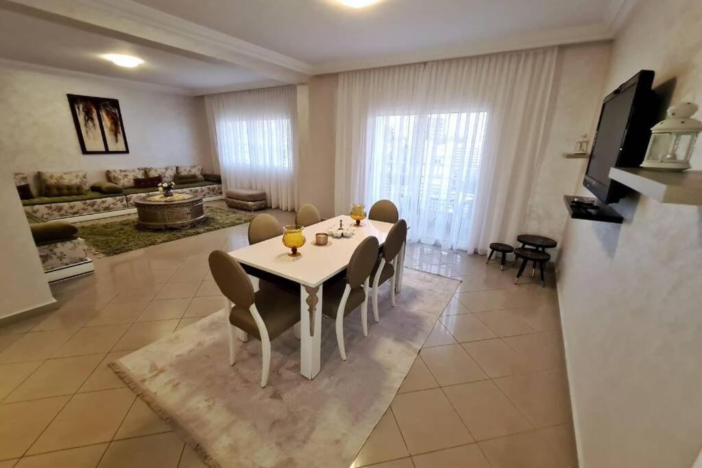 uma sala de jantar com uma mesa branca e cadeiras em Appartement Haut Standing en plein centre ville em Agadir