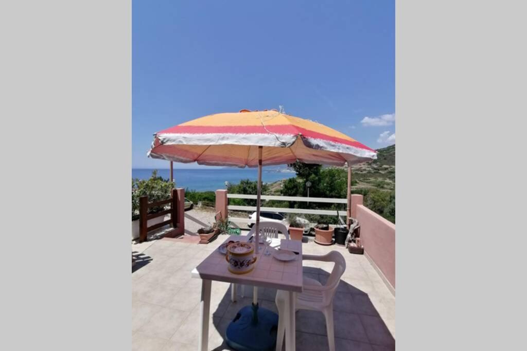 patio ze stołem i parasolem w obiekcie Appartamento vista mare con terrazza Bosa Turas w mieście Magomadas