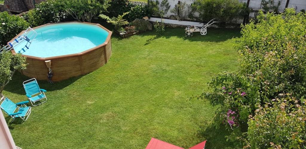 een uitzicht op een achtertuin met een bad in het gras bij 3 bedrooms apartement at A Guarda 800 m away from the beach with sea view enclosed garden and wifi in A Guarda