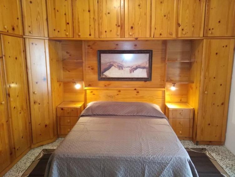 1 dormitorio con 1 cama en una pared de madera en St. Mary en Qormi