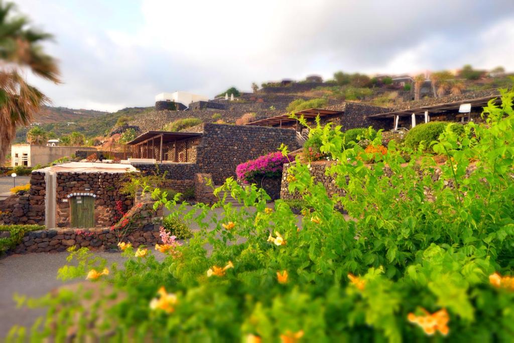 a building with a bunch of flowers in front of it at Dammusi al Tramonto in Pantelleria
