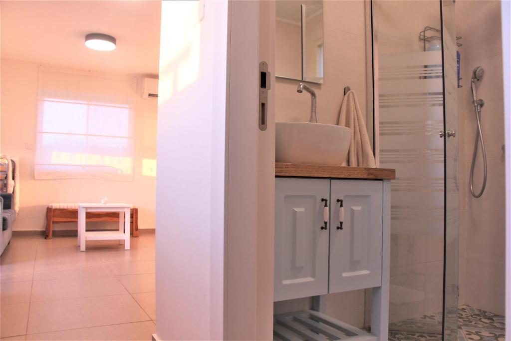 ein Bad mit einer Dusche und einem Waschbecken in der Unterkunft צימר מול השקיעה in Retamim