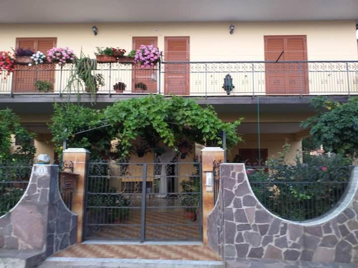 a building with a gate and a balcony with flowers at Casa Ester in Ascea