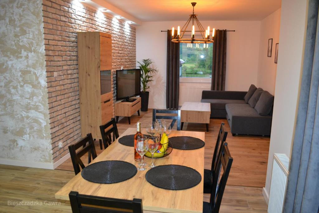 comedor y sala de estar con mesa y sillas en Apartament całoroczny Bieszczadzka Gawra, en Ustrzyki Dolne