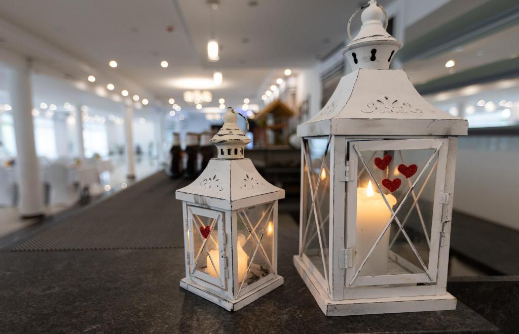 Decorative lanterns with candles on a counter in a well-lit room.