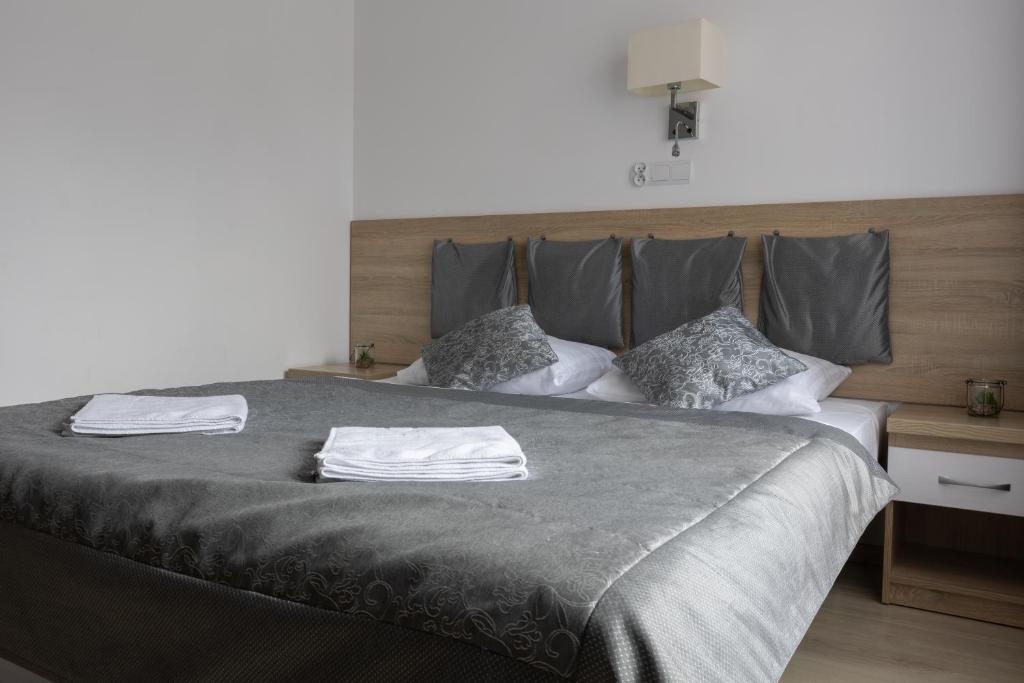 Close-up of bed with gray bedding and decorative pillows.