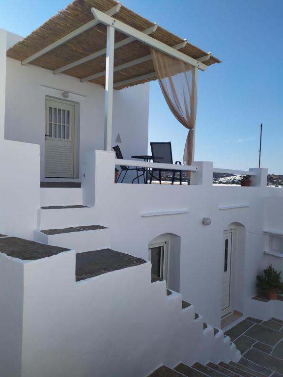 een wit huis met een trap en een tafel bij Melissou place in Apollonia