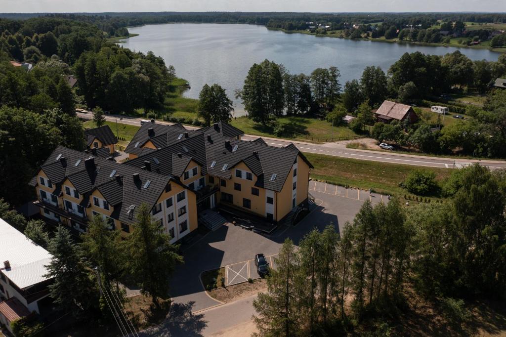 Hotel complex near a lake, surrounded by trees and roads.