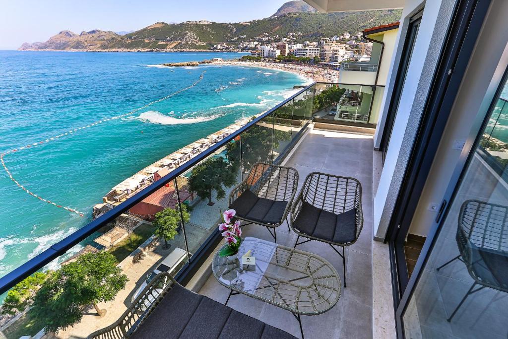 balcone con sedie, tavolo e vista sull'oceano di APARTMENTS MERLIN a Dobra Voda